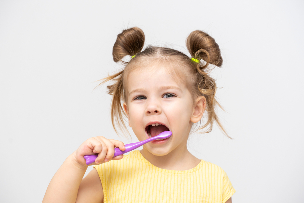 young girl brushing teeth