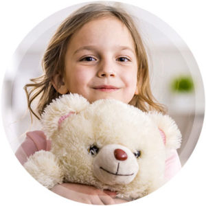 Child holding a teddy bear and receiving Special Needs Dental Care