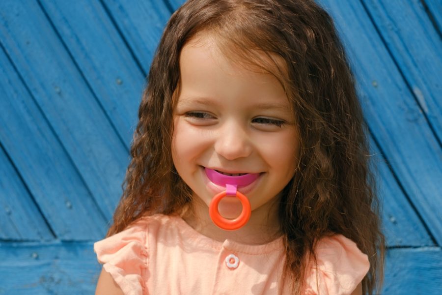 Laughing Baby With Mouthguard In Mouth For Bite Alignment. Crooked