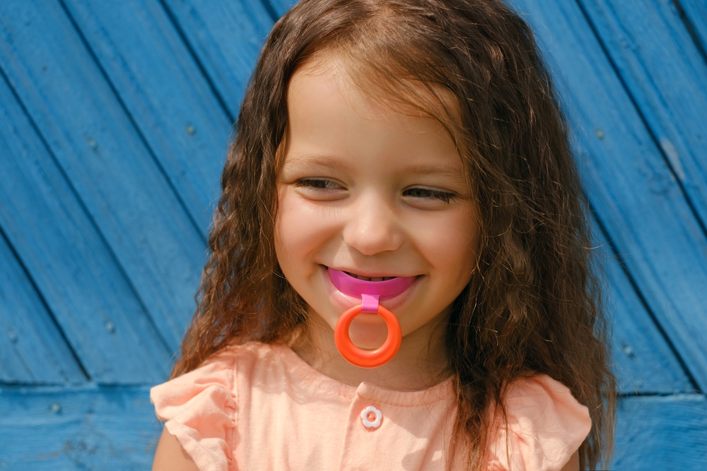 Laughing Baby With Mouthguard In Mouth For Bite Alignment. Crooked